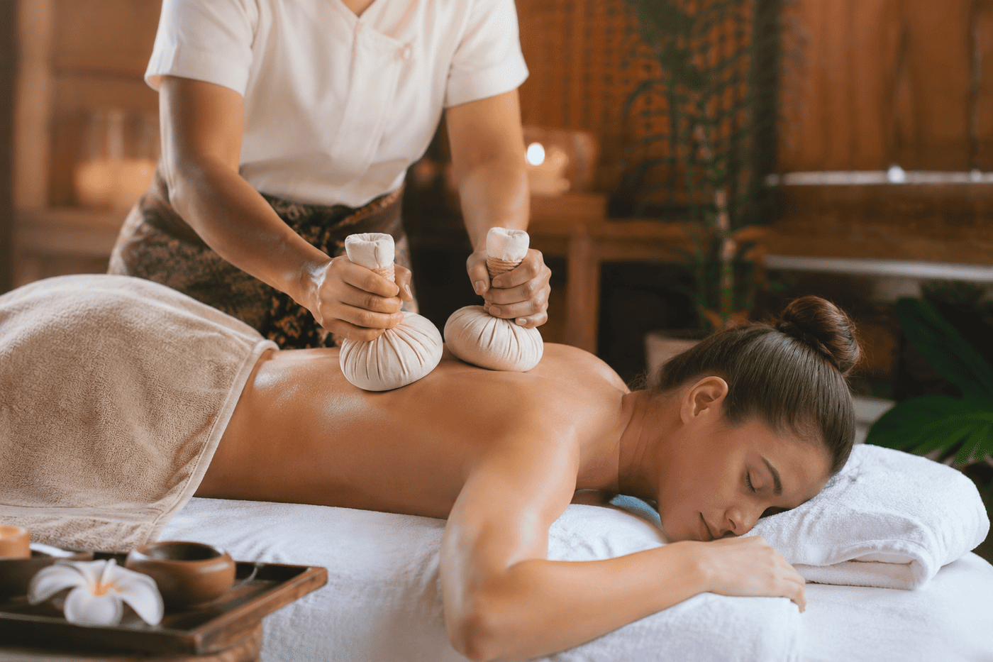Kräuterstempel werden in Öl erhitzt vor der Massage